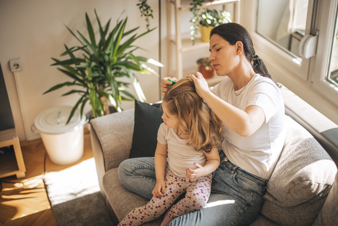 madre revisa cabeza de su hija