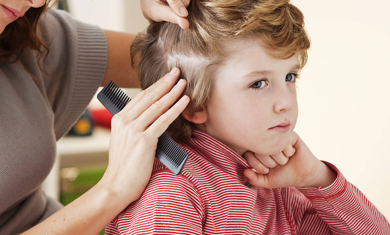 Madre revisa la cabeza de niño buscando piojos